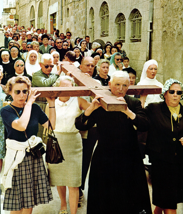 Christians worshipping according to their faith on the Via Dolorosa (the Way of Sorrows) in Jerusalem, carrying crosses. A scene from a film showing Prophet Isa (Jesus) carrying the cross along the Via Dolorosa.
